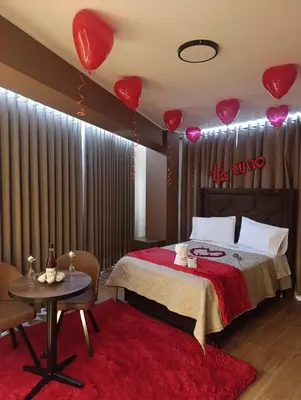 a room with a bed and a table with hearts on the ceiling at Kapricho Wanka in Huancayo