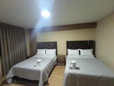 a bedroom with two beds with white sheets at Kapricho Wanka in Huancayo