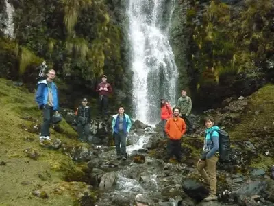 a group of people standing in front of a waterfall at EColodge Ccatan in Urubamba