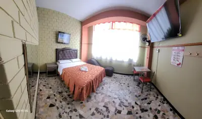 a bedroom with a bed and a large window at Las Estrellas Hostal in Puente Piedra