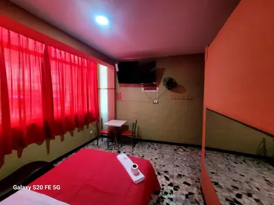 a red room with a table and a basketball hoop at Las Estrellas Hostal in Puente Piedra