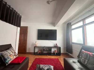 a living room with a couch and a tv on the wall at Legendary Rock Cusco Apartment in Cusco