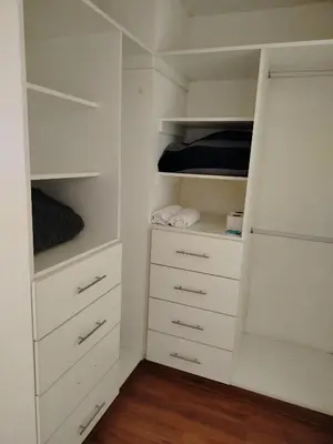 a walk in closet with white cabinets and drawers at Departamento Executive 2BR Balcón Frente al Mall Santa Catalina in Lima