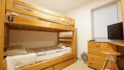 a bedroom with a bunk bed and a desk at Edificio Sir William - Punta hermosa - Lima, Peru in Punta Hermosa