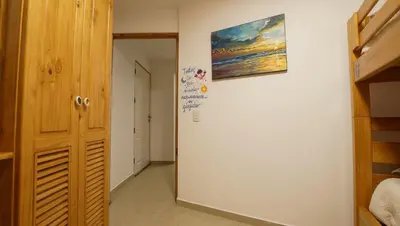 a hallway with a door and a painting on the wall at Edificio Sir William - Punta hermosa - Lima, Peru in Punta Hermosa