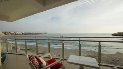 a balcony with chairs and a view of the beach at Edificio Sir William - Punta hermosa - Lima, Peru in Punta Hermosa