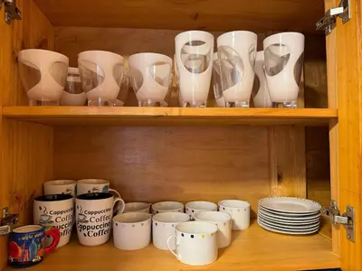 a wooden shelf with cups and plates and glasses at Edificio Sir William - Punta hermosa - Lima, Peru in Punta Hermosa