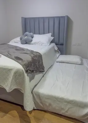 a bedroom with two beds and a gray headboard at Brand new apartment in the heart of Miraflores in Lima