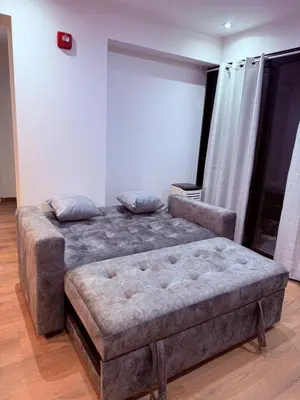 a bedroom with a bed and a ottoman at Brand new apartment in the heart of Miraflores in Lima