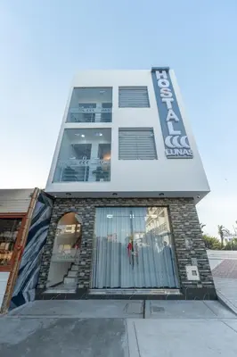 a tall building with a staircase in front of it at Hostal 3 Lunas in Paracas