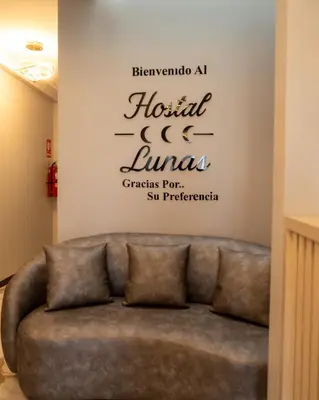a couch in a room with a sign on a wall at Hostal 3 Lunas in Paracas