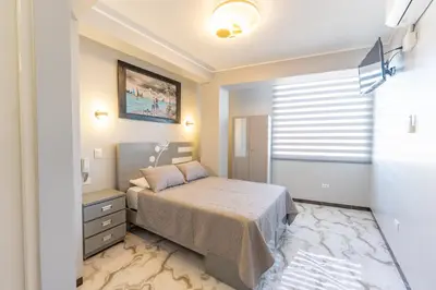 a small bedroom with a bed and a window at Hostal 3 Lunas in Paracas