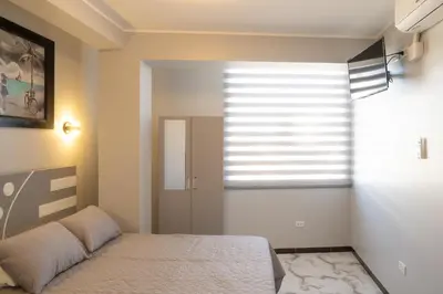 a bedroom with a bed and a large window at Hostal 3 Lunas in Paracas