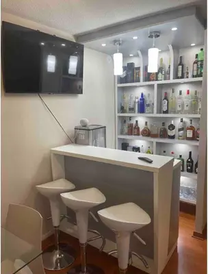 a kitchen with a bar with stools and a tv at New Apartment near the airport with parking in Lima