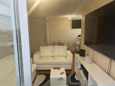 a living room with a white couch and a television at New Apartment near the airport with parking in Lima