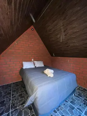 a bed in a brick room with towels on it at AndeStay Hostel Chaullay in Colcapampa