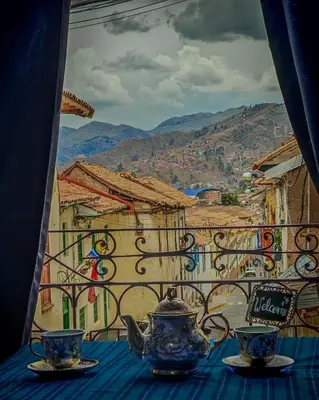 a table with two tea pots and cups on a balcony at Tres Reyes Hospedaje in Cusco