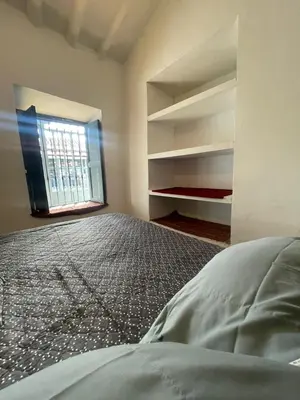 an empty room with a bed and a window at Tres Reyes Hospedaje in Cusco
