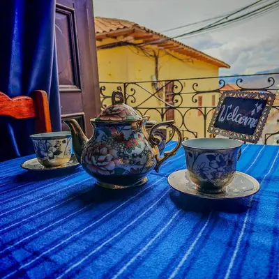 a blue table with a tea pot and two cups at Tres Reyes Hospedaje in Cusco