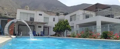 a swimming pool with a fountain in front of a building at Casa de Campo Las Siete Gotas - Cieneguilla in Cieneguilla