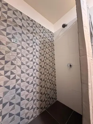 a bathroom with a shower with a tiled wall at Private cinema & comfort in cultural Barranco in Lima
