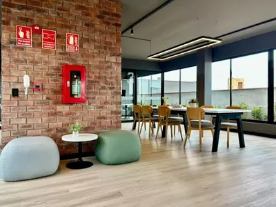 a dining room with tables and chairs and a brick wall at Apartment in the center of Miraflores Larco in Lima