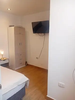 a bedroom with a bed and a tv on the wall at Casa Sunampe Chincha in Sunampe