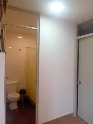 a bathroom with a toilet and a glass door at Casa Sunampe Chincha in Sunampe