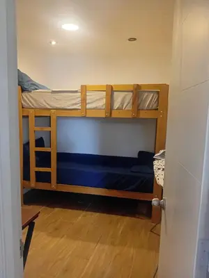 two bunk beds in a room with blue sheets at Casa Sunampe Chincha in Sunampe