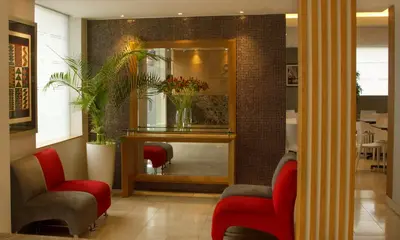 a waiting room with two red chairs and a mirror at Hotel San Remo in Lima