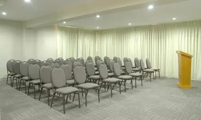 a row of chairs in a room with a podium at Hotel San Remo in Lima