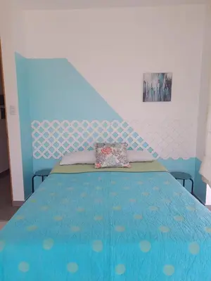 a bedroom with a bed with a blue head board at Asia las terrazas casa in Asia