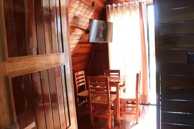 a dining room with a table and chairs and a television at Alpinas Natural Suites in Lunahuaná