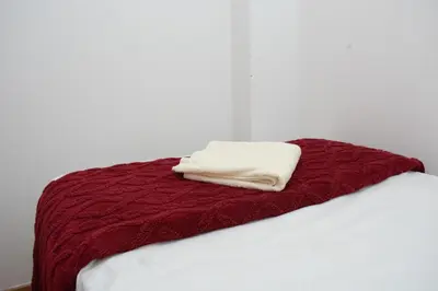a red blanket laying on top of a bed at Apart Hotel Alojate Kaypi in Ayacucho