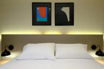 a bedroom with a bed with two pictures above it at Larco Prime Suites - Pool, Gym & Coworking in Lima