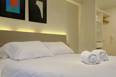 a bedroom with a white bed with towels on it at Larco Prime Suites - Pool, Gym & Coworking in Lima