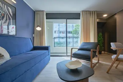 a living room with a blue couch and a chair at Larco Prime Suites - Pool, Gym & Coworking in Lima