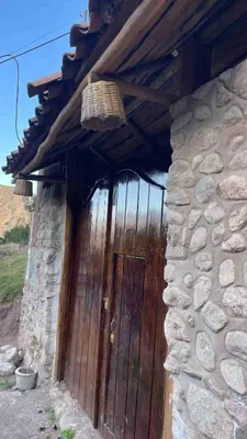 a wooden door on the side of a stone building at Casa de Campo en el Valle Sagrado de los Incas, Urubamba - Unu Samay in Urubamba