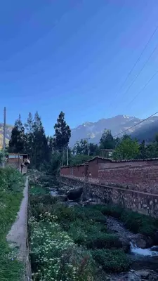 a dirt road next to a river with mountains in the background at Casa de Campo en el Valle Sagrado de los Incas, Urubamba - Unu Samay in Urubamba