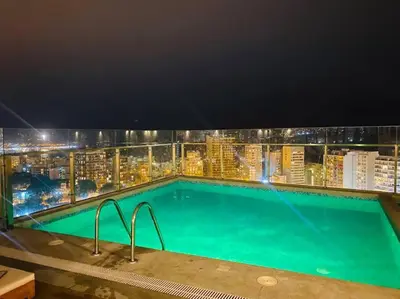a swimming pool on the roof of a building at night at Loft en Barranco in Lima