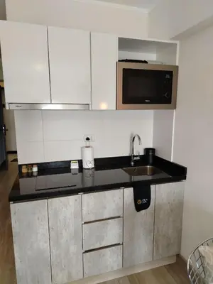 a kitchen with a sink and a microwave at Loft en Barranco in Lima