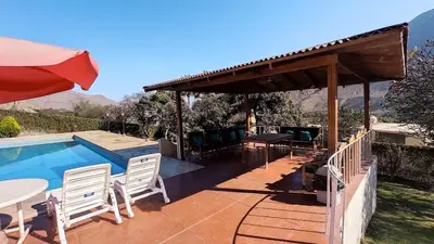 a swimming pool with a pavilion and a table and chairs at Casa de campo Yangas para 20 personas in Yangas