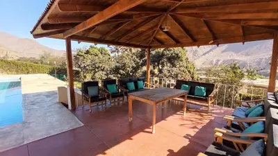 a patio with a table and chairs and a pool at Casa de campo Yangas para 20 personas in Yangas