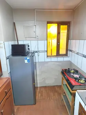 a small kitchen with a refrigerator and a window at Mayu House Inn IV en el centro histórico in Cusco