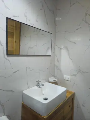a white bathroom with a sink and a mirror at La Montaña Lodge - Oxapampa in Oxapampa