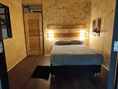 a bedroom with a bed with lights on the wall at La Montaña Lodge - Oxapampa in Oxapampa