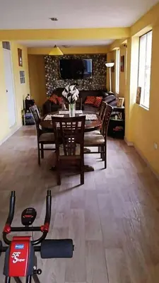 a living room with a table and chairs and a tv at Residencial Huancaro Apartament in Cusco