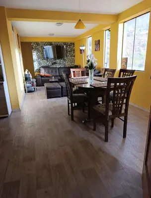 a living room with a dining room table and chairs at Residencial Huancaro Apartament in Cusco