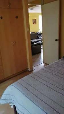 a bedroom with a bed and a living room at Residencial Huancaro Apartament in Cusco