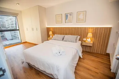 a bedroom with a bed with two slippers on it at BSR Brand New Apt Near Larcomar w/ Parking & Gym in Lima